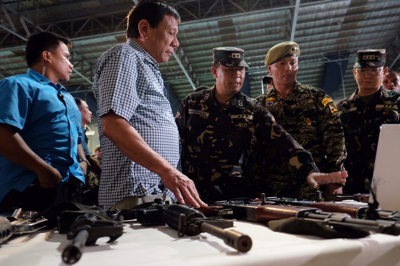 NPA GUNS. President Rodrigo Duterte checks the firearms recovered from the New People's Army rebels during his visit at Camp Edilberto Evangelista in Patag, Cagayan de Oro City on August 9, 2016. Malacañang file photo 