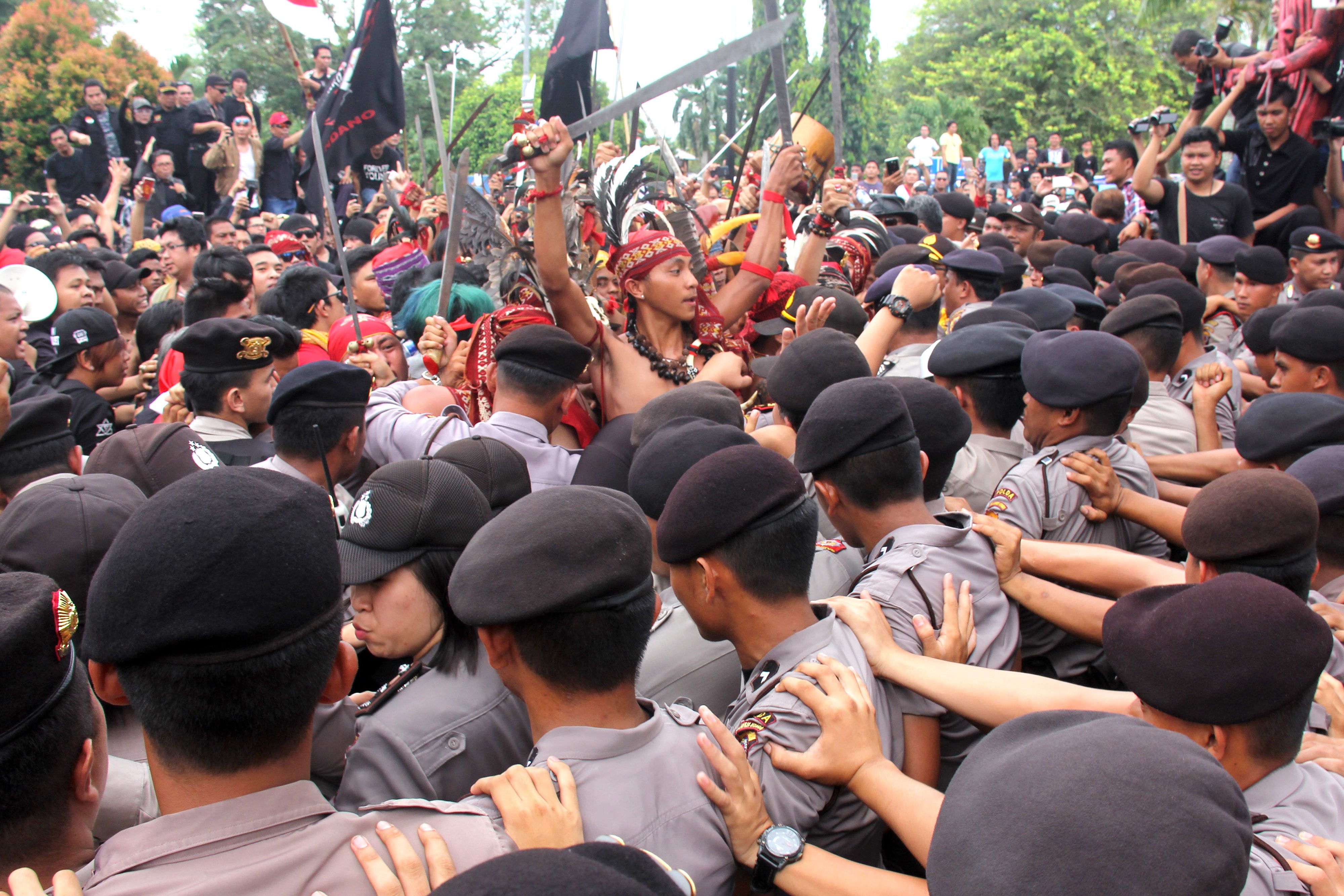 UNJUK RASA. Pengunjuk rasa berupaya memasuki halaman Kantor Gubernur Sulut di Manado, Sulawesi Utara, Sabtu, 13 Mei. Foto oleh Kalino/ANTARA 
