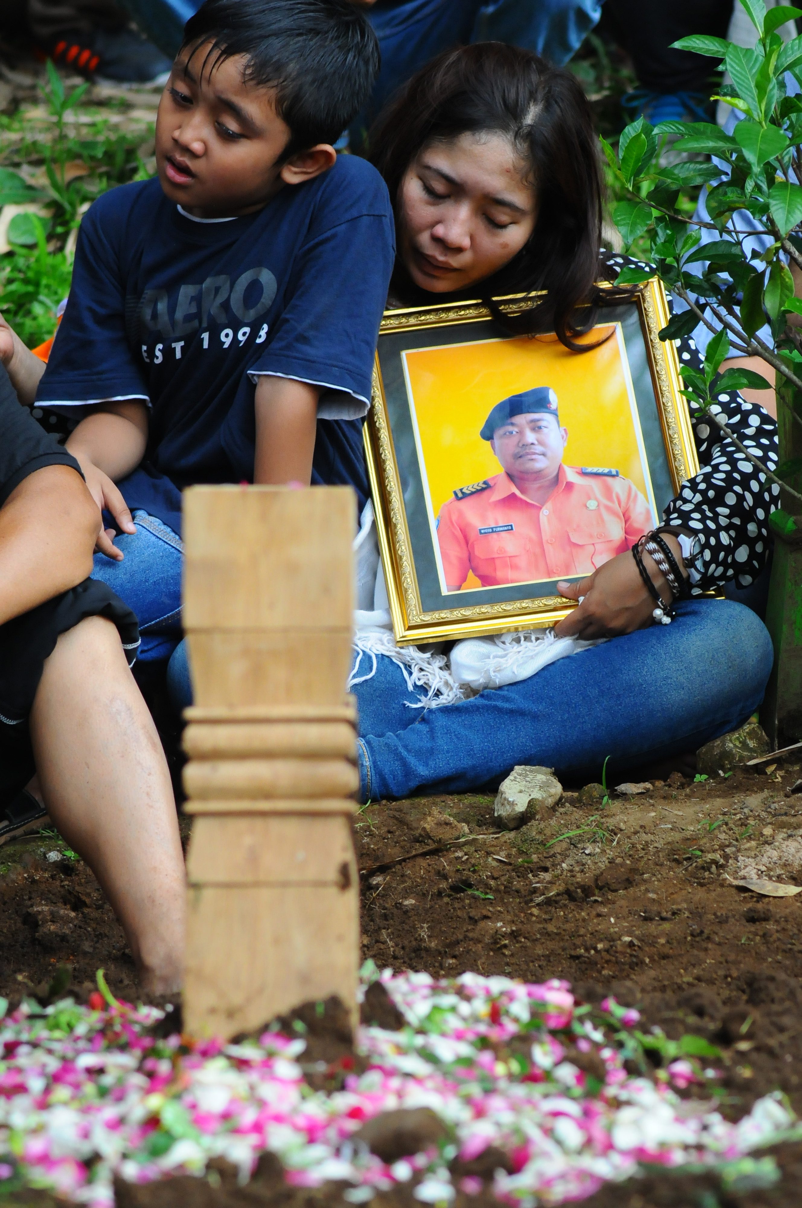 Keluarga memeluk foto almarhum Nyoto Purwanto, korban kecelakaan helikopter milik Basarnas saat prosesi pemakaman. Foto oleh Aloysius Jarot Nugroho/Antara 