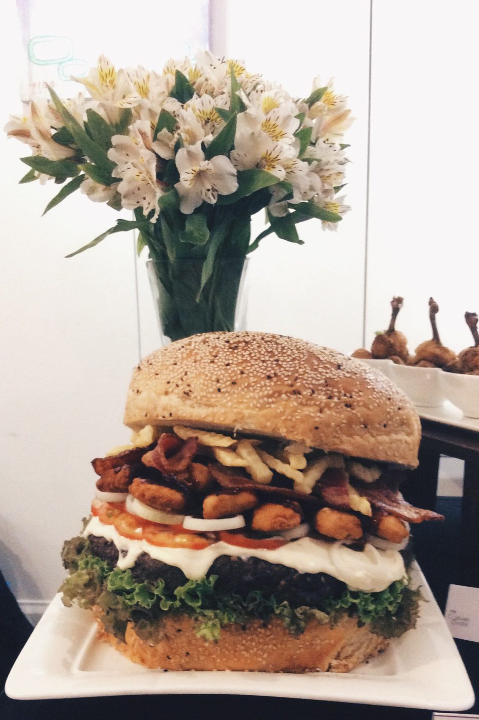 MONSTER BURGER. The angus burger is served with vegetables, cheese, chicken nuggets, fries and bacon. 