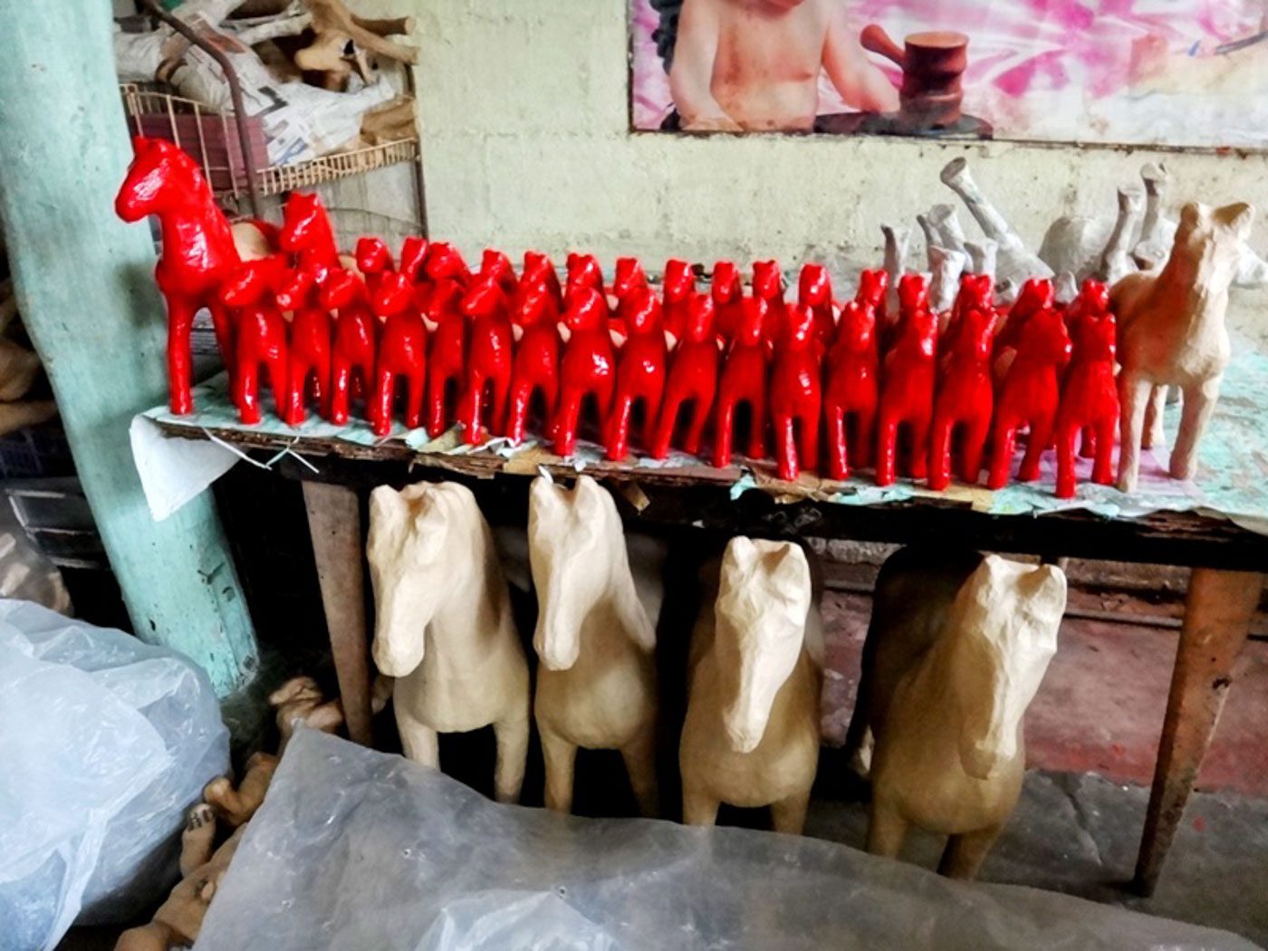 PAPER HORSES. Bright red and plain papier mâché horses for painting. 