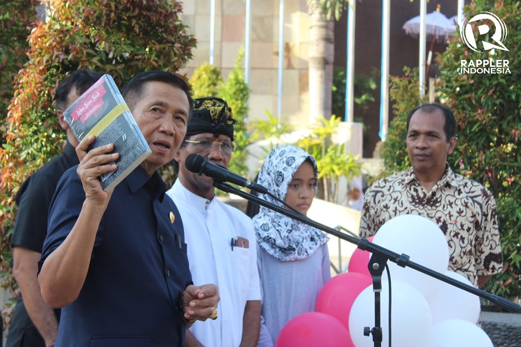 BUKU. Gubernur Bali Made Mangku Pastika saat menunjukkan buku berjudul Luka Bom Bali. Foto oleh Bram Setiawan/Rappler 