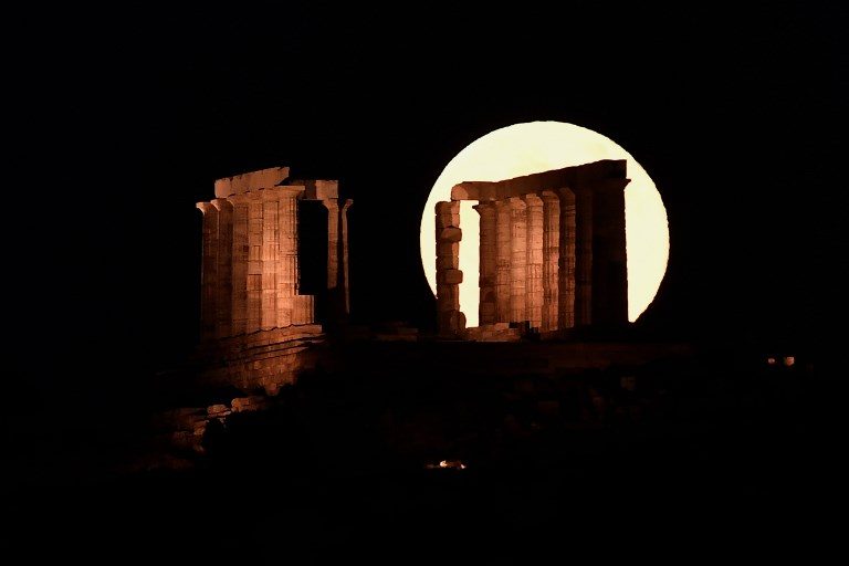 MOON RISE. The full moon rises behind the Temple of Poseidon in Sounion in Athens, Greece on June 28, 2018. Photo by Louisa Gouliamaki/AFP  