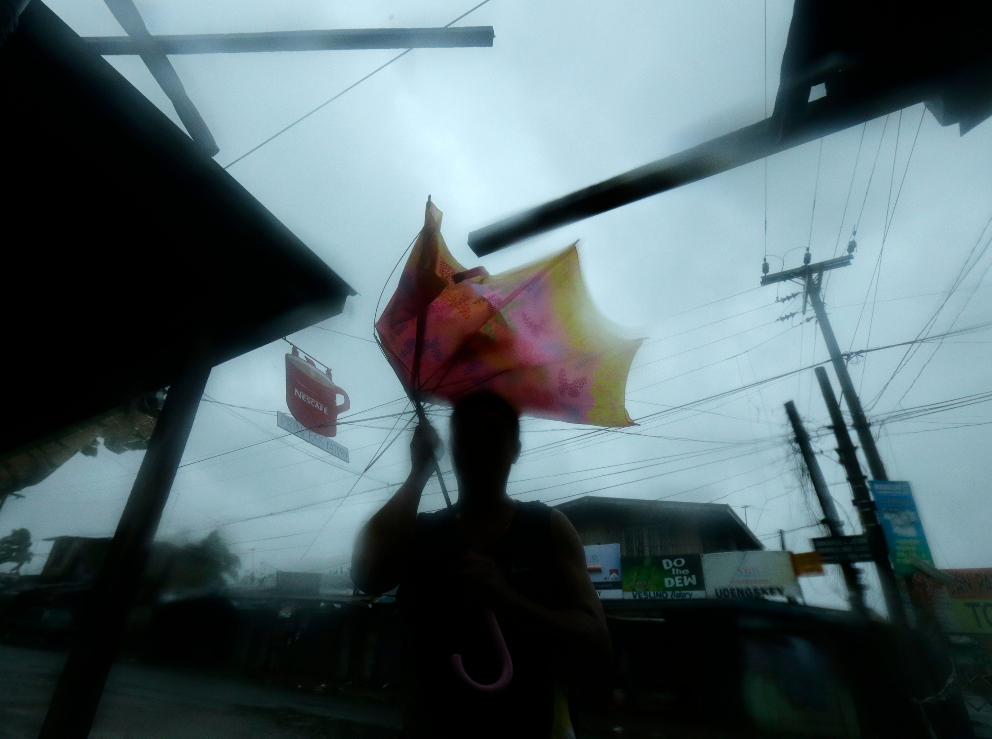 A resident of Munoz, Nueva Ecija holds an umbrella blown by the strong winds of Typhoon Lando (Koppu) after it made landfall. Photo by Francis Malasig/EPA 