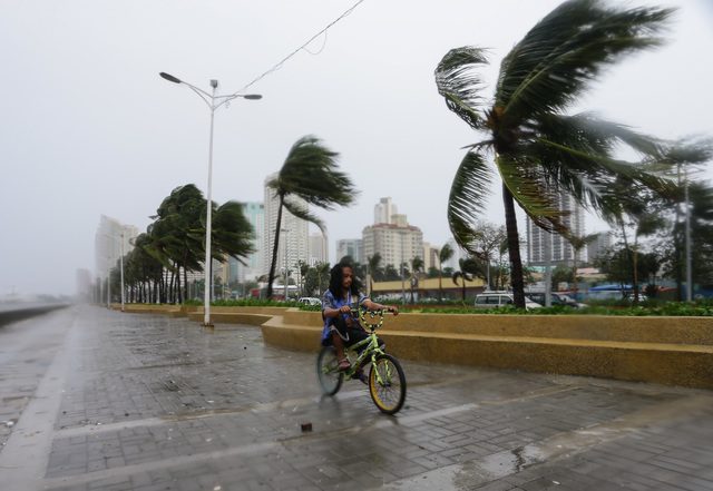 NO-WALK ZONE. A biker braves the strong winds and rains in Manila. Photo by Mark Cristino/EPA 