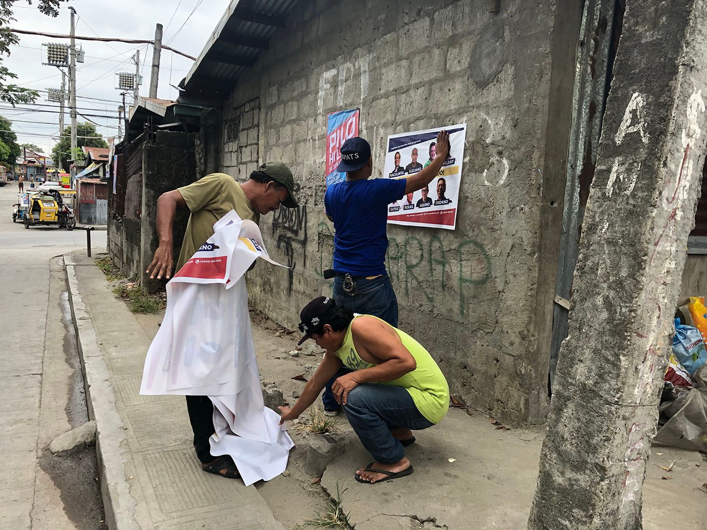 THE VOLUNTEERS. Otso Diretso campaign volunteers put up campaign posters of Otso Diretso just before the candidates arrive for their dialogue with residents of Southville 3, Muntinlupa on March 5, 2019. Photo by Mara Cepeda/Rappler  