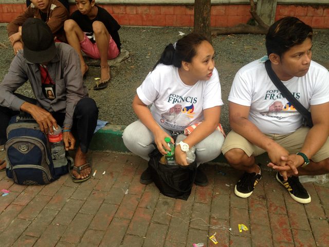 GETTING READY. Marlon and Rachel Hernandez wait along a pavement in Luneta Park for Pope Francis’ arrival. Photo by David Lozada/ Rappler
