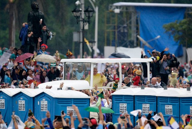Pope Francis aboard his popemobile drive past the statue of Filipino San Lorenzo Ruiz while greeting the faithful prior to his mass at the Quirino grandstand. Photo by Dennis Sabangan/EPA
