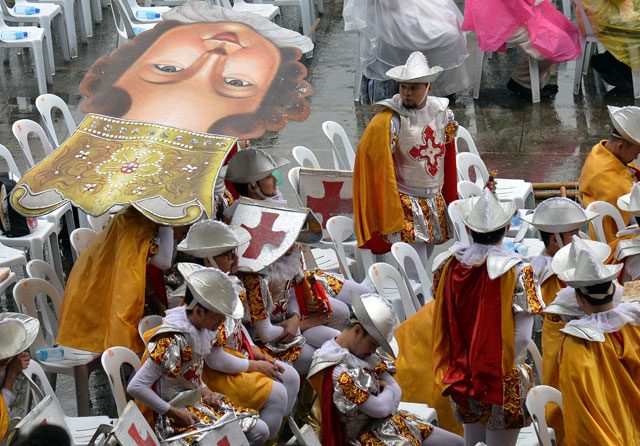 Sinulog presentors take a rest prior to the start of Pope Francis' mass at the Quirino grandstand. Photo by Ettore Ferrari/EPA