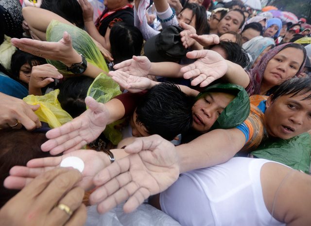 Outstretched hands to receive communion during a mass celebrated by Pope Francis at the Quirino grandstand in Manila on January 18, 2015. Photo by Francis Malasig/EPA