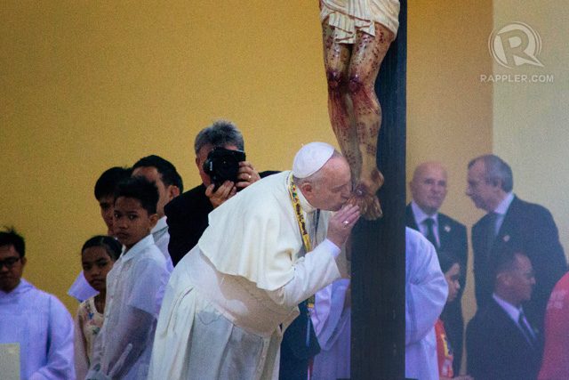 Pope Francis kisses the feet of the statue of Jesus Christ prior to the start of the encounter with the youth at the University of Santo Tomas. Photo by Kimberly Wee-Ebol/Move.PH