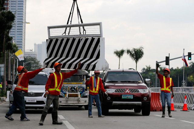 PAPAL SECURITY. Workers lay concrete barriers for crowd control on a road where Pope Francis is expected to pass during his 4-day visit. Photo by Francis Malasig/EPA