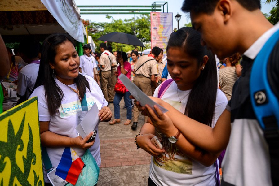 REACHING OUT. Tanghalang Pilipino members gives pamphlets to viewers during their performance 