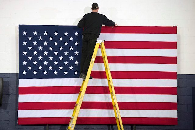 PRIMARY NIGHT. A worker stands on a ladder in front of the US national flag before a primary night party for Democratic presidential candidate Hillary Clinton, at Southern New Hampshire University in Hooksett, New Hampshire, USA, February 9, 2016. Michael Reynolds/EPA 