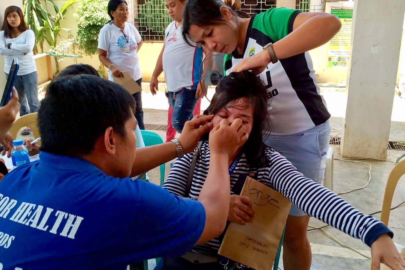 OUCH! Health workers attend to a poll volunteer of Tingog Partylist after she was stabbed with a ballpen by a rival volunteer in Matuginao, Samar. Photo by Jazmin Bonifacio/Rappler   