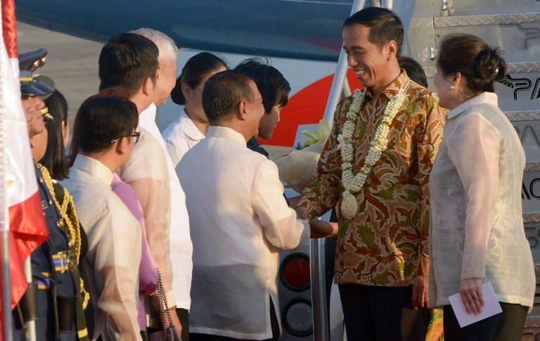 WELCOME TO MANILA, JOKOWI. Indonesia's President Joko Widodo (2nd R) is welcomed by Philippine Vice President Jejomar Binay (C) upon his arrival in Manila on February 8, 2015. Jay Directo/AFP 