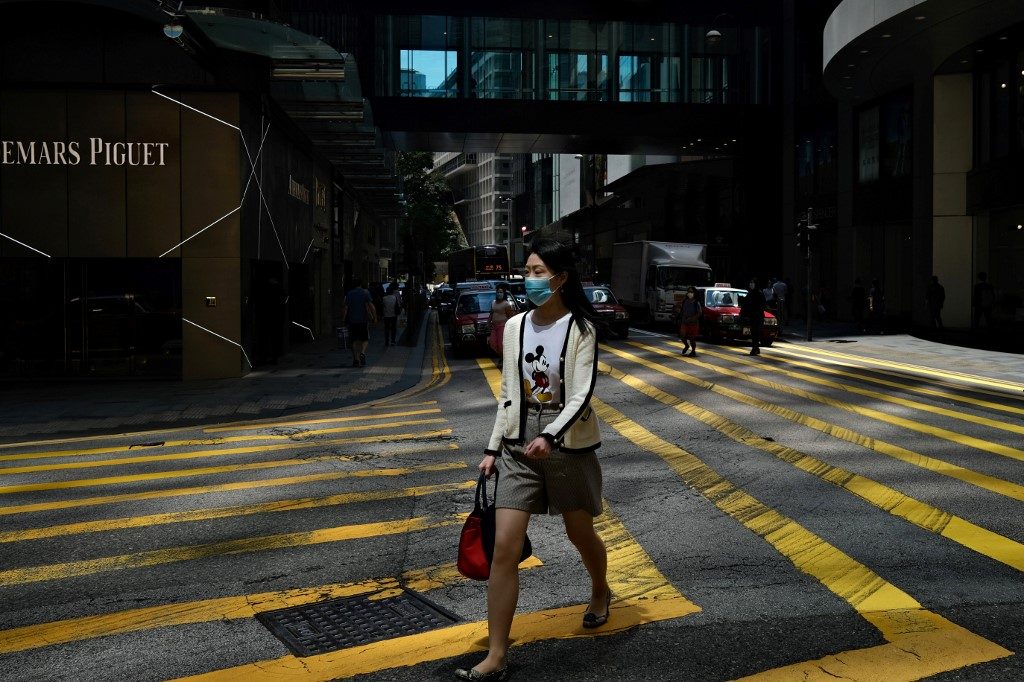 PHYSICAL DISTANCING. A woman wears a face mask as she walks across a zebra crossing in Hong Kong on April 28, 2020. Photo by Anthony Wallace/AFP 