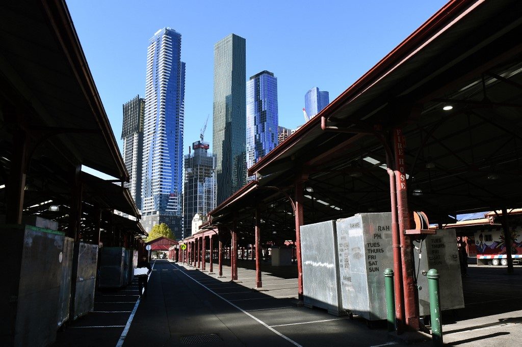 DESERTED. A man (L) walks through a deserted part of Melbourne's Queen Victoria Market on May 5, 2020. Photo by William WEST/AFP 