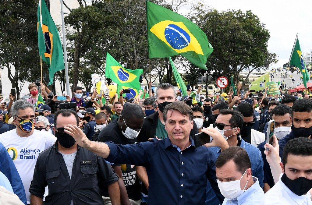 Bolsonaro rallies with supporters amid coronavirus surge, takes off mask