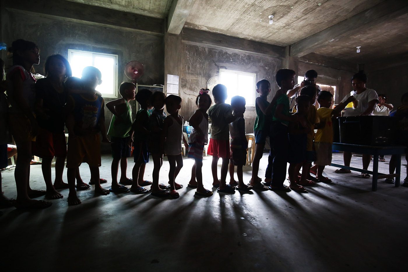 FOOD LINE. Children queue for free bread and juice during a feeding program in Baseco, Manila, on July 4, 2018, as President Rodrigo Duterte recently signs into law the establishment of a national feeding program to address hunger and undernutrition. Photo by Ben Nabong/Rappler   