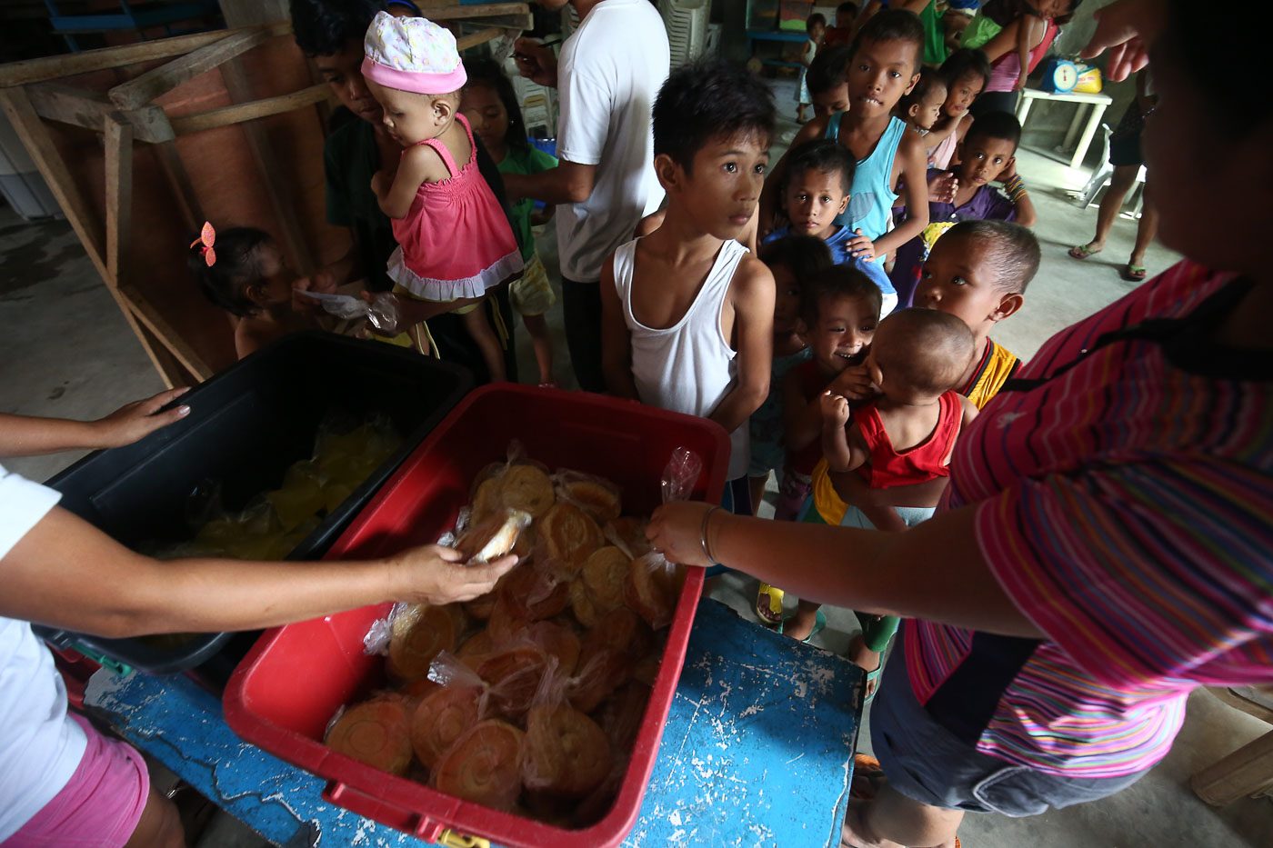 FEEDING PROGRAM. Children queue for free ensaymada and juice during a feeding program in Baseco, Manila on July 4, 2018, as President Rodrigo Duterte recently signs into law the establishment of a national feeding program to address hunger and undernutrition. Photo by Ben Nabong/Rappler  
