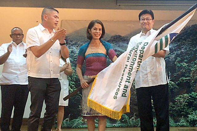 TRANSITION. Former environment secretary Ramon Paje hands the flag of the department to Environment Secretary Gina Lopez. Photo by Jee Geronimo/Rappler  