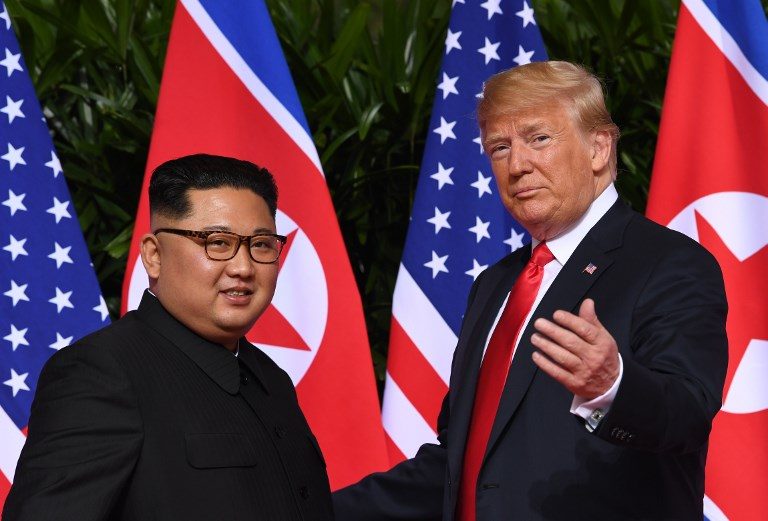 TRUMP-KIM SUMMIT.US President Donald Trump (R) gestures as he meets with North Korea's leader Kim Jong Un (L) at the start of their historic US-North Korea summit, at the Capella Hotel on Sentosa island in Singapore on June 12, 2018. Photo by Saul Loeb/AFP 