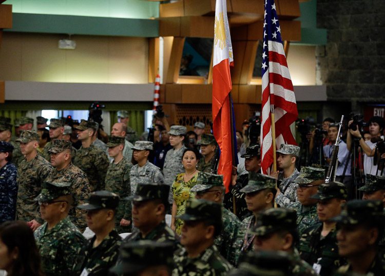 SHOULDER-TO-SHOULDER. Military troops from the Philippines and United States hold up their respective national flags during opening rites of the Philippines-US Exercise Balikatan in Quezon City on April 20 2015.  Photo by Ritchie Tongo/EPA 