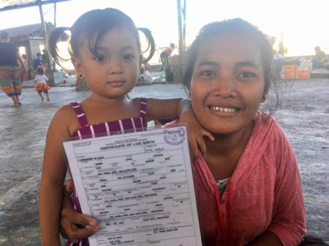  A young mother holds the laminated copy of her childâs birth certificate inside the Brgy 23-C Gym where some families are still staying after the huge fire that hit their community last Feb. 20 