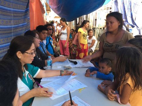 Balma Sarapudin (right side in brown shirt), an active member of the Pagtimukan Mabajau Kauman, assists and translates for mothers as their papers are being processed by Local Civil Registry officials 