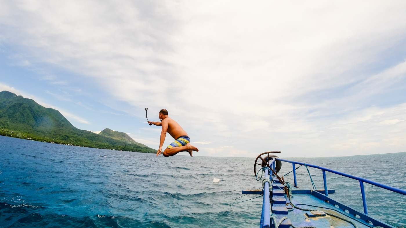 SHOWTIME. Tourist Kristian Marfori jumps off the boat as he enjoys snorkeling off Camiguin Island. Photo by Bobby Lagsa/Rappler 