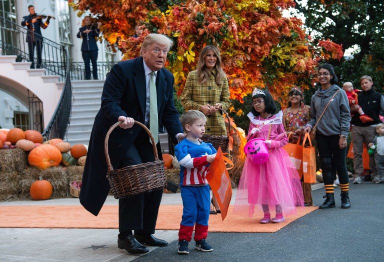 TREATS. US President Donald Trump and First Lady Melania Trump give out candy to children at a Halloween celebration at the White House in Washington on October 28, 2018. Photo by Nicholas Kamm/AFP 