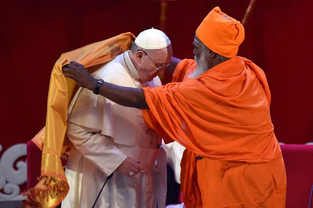 Pope Francis receives a saffron-colored robe by Hindu Kurukkal SivaSri T. Mahadeva during the interreligious meeting. Photo by Ettore Ferrari/EPA