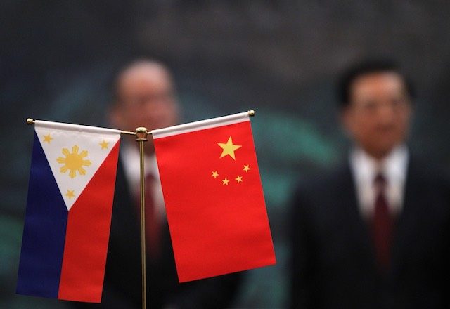 In this file photo, the Philippines' and China' national flags are seen as Philippine President Benigno Aquino III (L) and his Chinese counterpart Hu Jintao stand in the background during a signing ceremony in the Great Hall of the People in Beijing, China on August 31, 2011. How Hwee Young/EPA 
