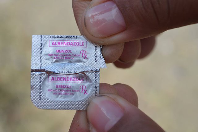 EXPIRED? An angry parent shows the package of the deworming medicine allegedly administered to students in Zamboanga del Norte. The expiration date on the top of the package is Dec 2012. File photo by Gualberto Laput/Rappler      