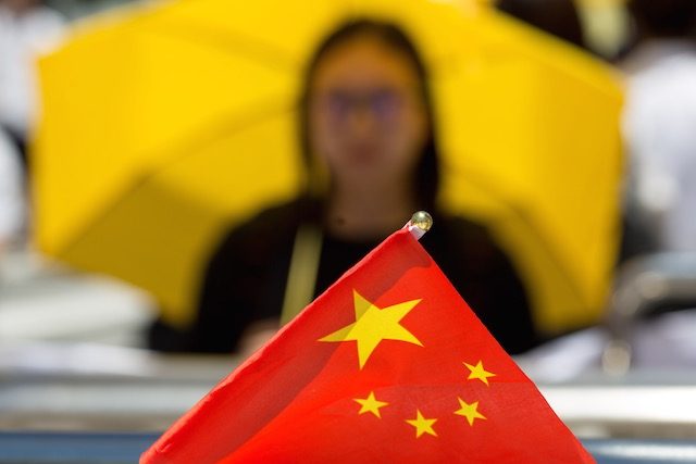 YELLOW VS RED. A pro-democracy supporter holds a yellow umbrella outside the Legislative Council in Hong Kong, China, June 18, 2015. Jerome Favre/EPA 