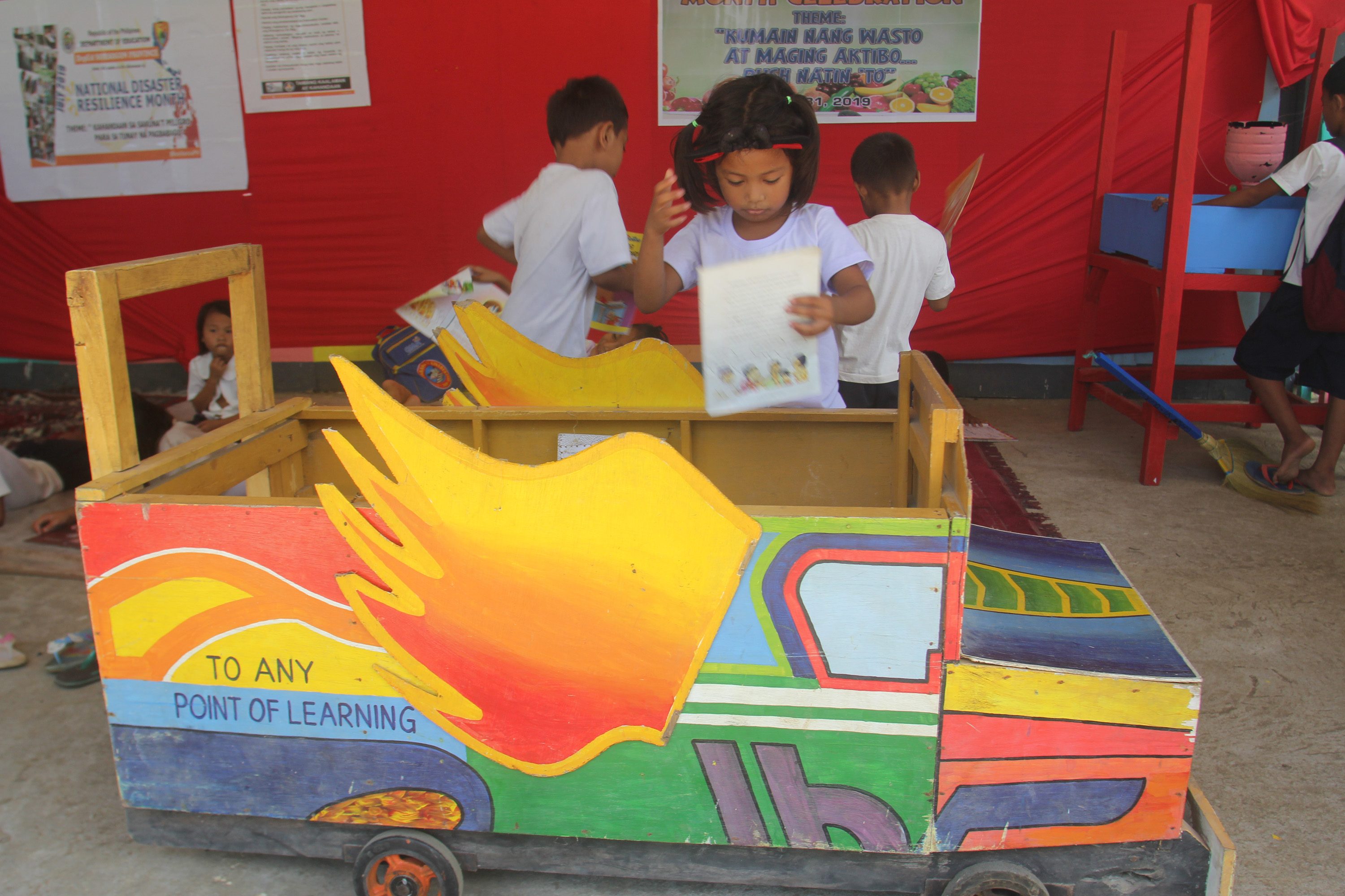 CONDUCIVE TO READING. A student gets a book from a jeepney-inspired reading kiosk at Calongay Elementary School. Photos by Rhaydz Barcia/Rappler 
