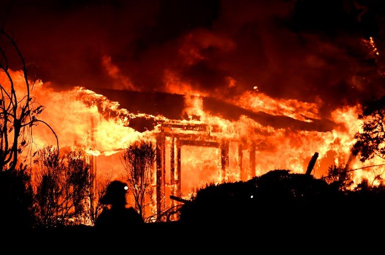 WILDFIRE. Firefighters assess the scene as a house burns in the Napa wine region of California on October 9, 2017. Photo by Josh Edelson/AFP    