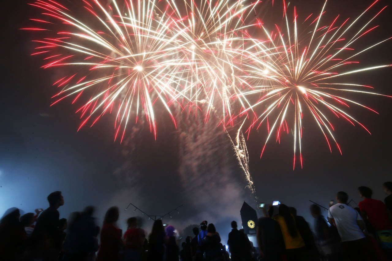 GRAND WELCOME. Families enjoy the  fireworks display despite of the rain in Luneta, Manila, during the New Year's Eve revelry on January 1, 2019. Photo by Ben Nabong 