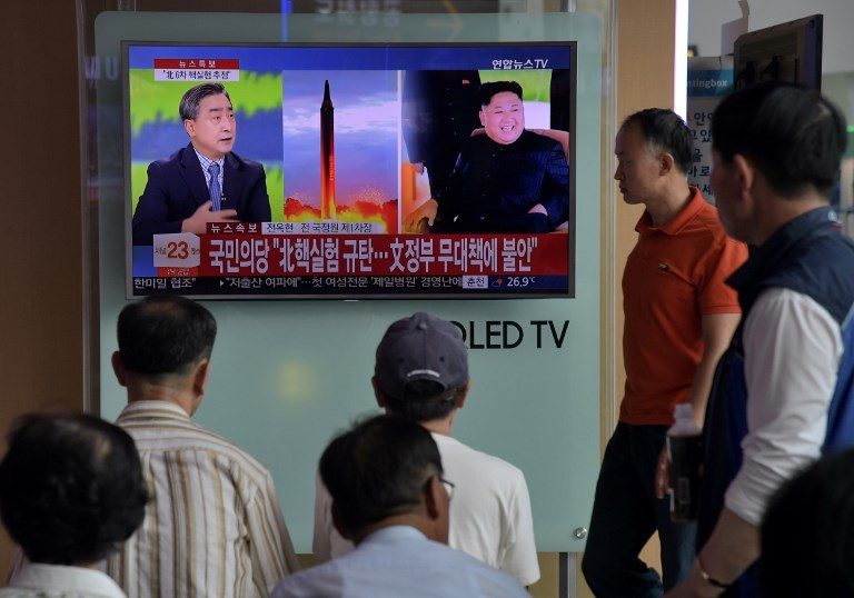 People watch a television display at a train station in Seoul on September 3, 2017 showing a news broadcast about North Korea's latest possible nuclear test. Ed Jones/AFP 