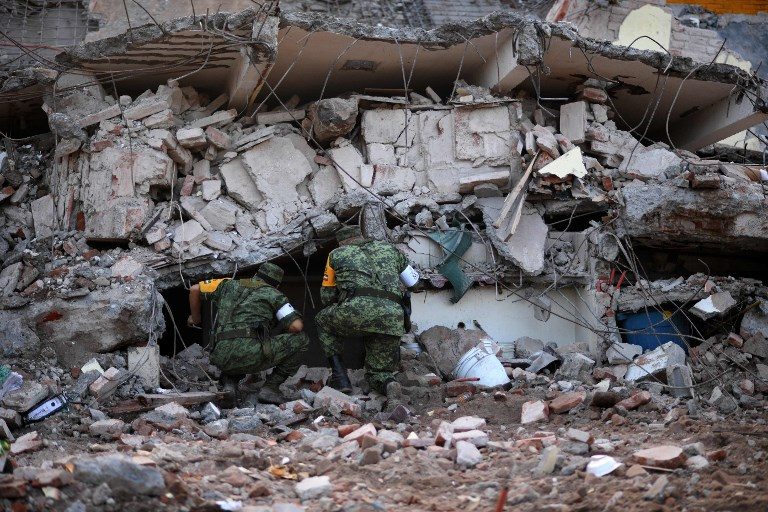 SEARCH AND RESCUE. Soldiers with specially trained dogs search for survivors amid the ruins of buildings knocked down by a magnitude 8.1 quake in Juchitan de Zaragoza, Mexico, on September 9, 2017. Photo by Pedro Pardo/AFP 