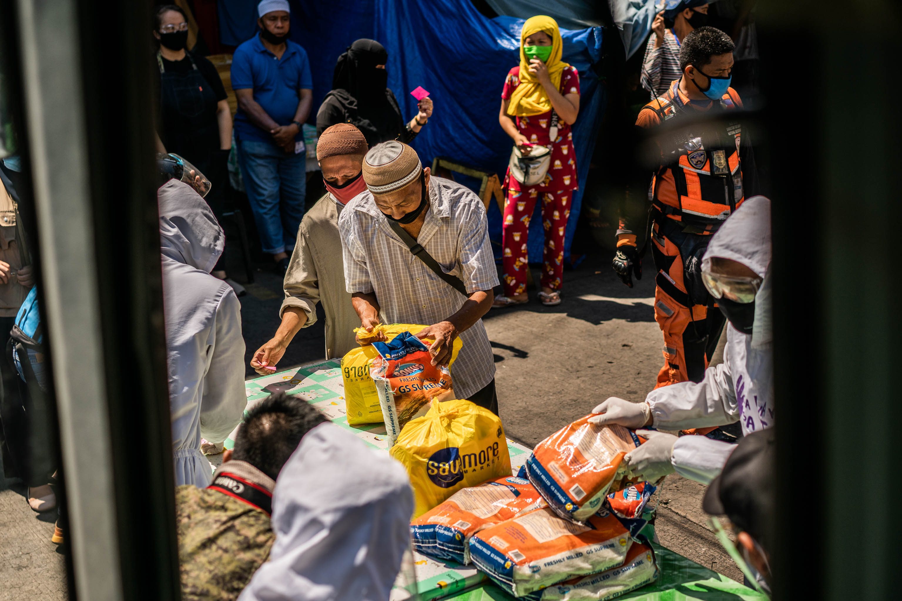 RELIEF EFFORT. Families line up for relief goods being distributed in an event facilitated by Tajannah Basman on May 19, 2020, in Quiapo, Manila.   