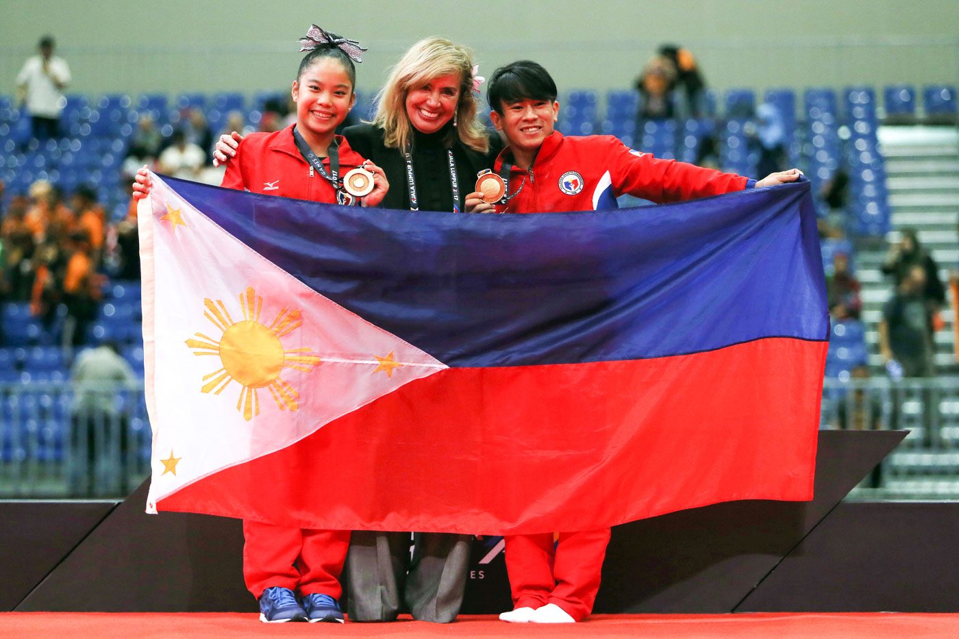 GOLDEN GYMNASTS. Reyland Capellan (R) and Kaitlin de Guzman (L) celebrate with Gymnastics Association of the Philippines and chef de mission Cynthia Carrion after winning two gold medals in gymnastics. Photo from PSC-POC Media Group 