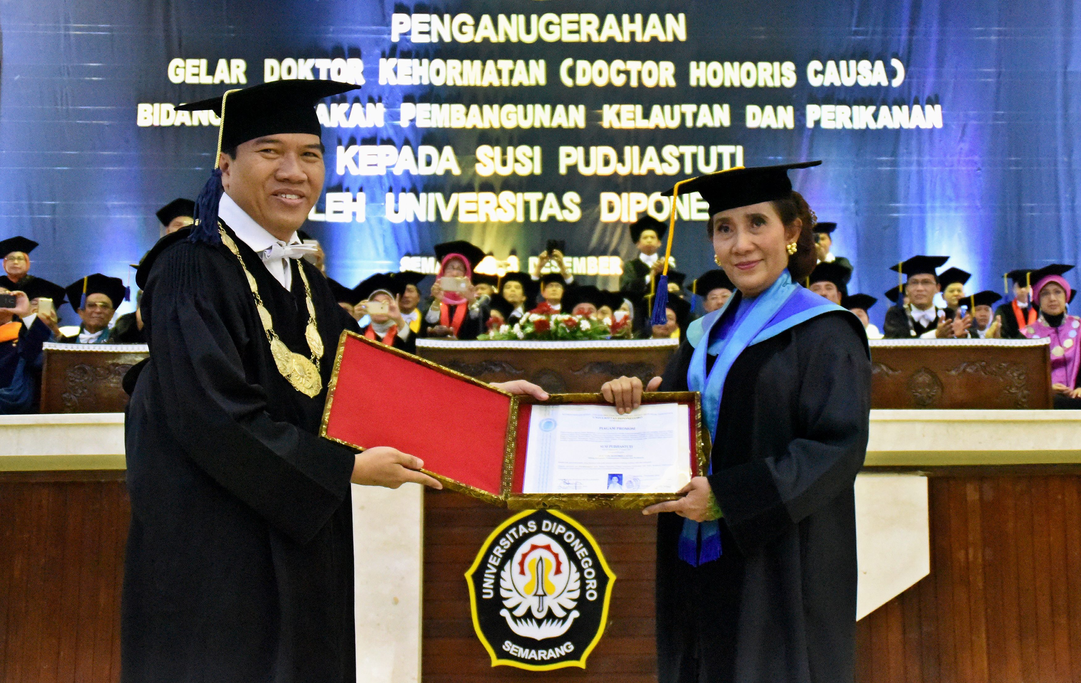 Menteri Kelautan dan Perikanan Susi Pudjiastuti (kanan) menerima piagam promosi dari Rektor Universitas Diponegoro (Undip) Yos Johan Utama pada penganugerahan gelar doktor kehormatan (honoris causa) pada 3 Desember 2016. Foto oleh R Rekotomo/Antara 