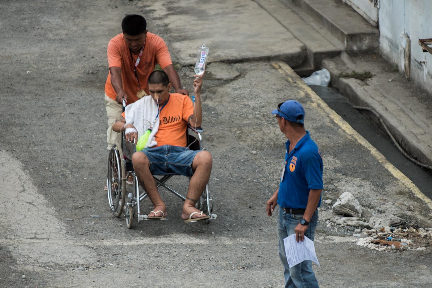 MEDICAL CARE NEEDED. A sick inmate's wheelchair is being pushed by another prisoner under the heat of the sun. Photo by Lisa Marie David/Rappler
 
