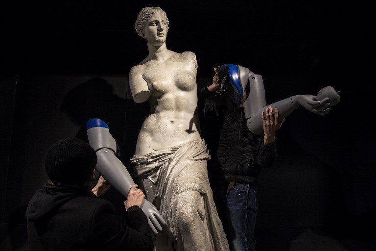 HANDICAP AWARENESS. Men dismantle the symbolicly attached prosthetic arms from a replica of the Venus de Milo during an action led by Handicap International to raise awareness on the thousands of amputees worldwide in need of a prosthesis, at the Louvre-Rivoli metro station in Paris on March 6, 2018. Photo by Christophe Archambault/AFP  