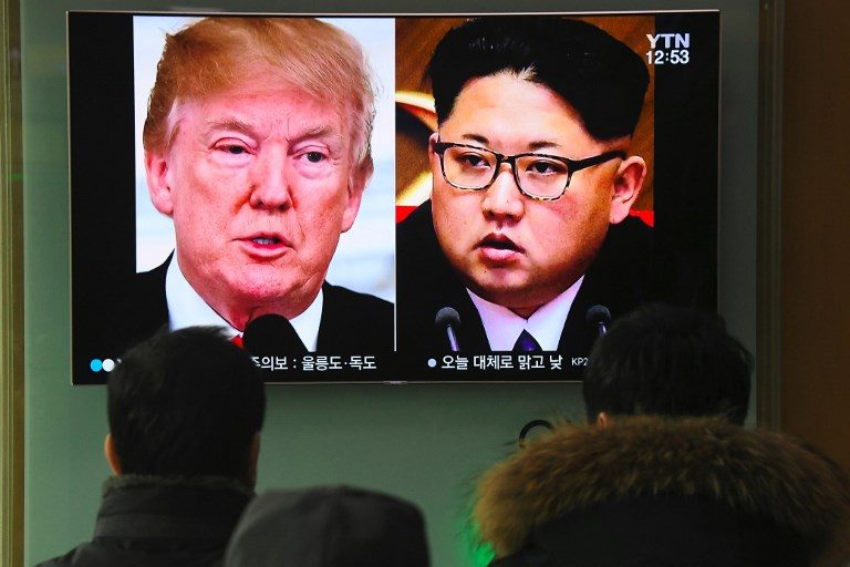 HISTORIC MEETING. People watch a television news report showing pictures of US President Donald Trump (L) and North Korean leader Kim Jong Un at a railway station in Seoul on March 9, 2018. Photo by Jung Yeon-je/AFP   