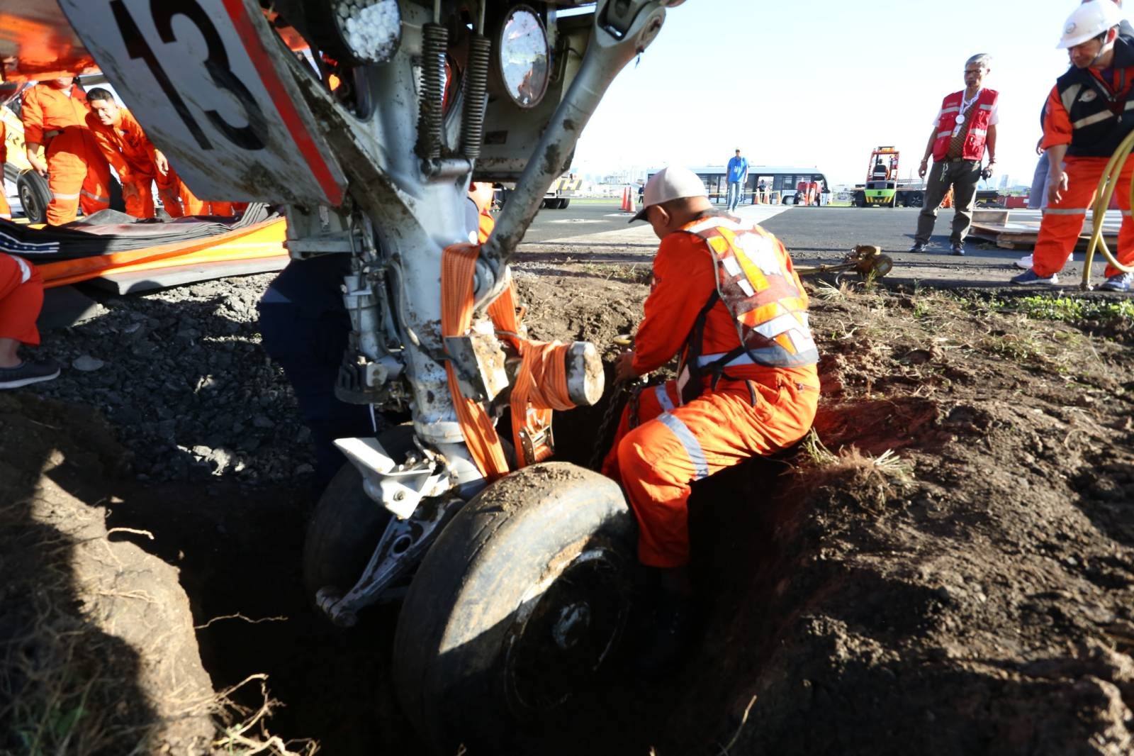 DIG. Airport authorities dig out the nose wheel that got stuck in the grassy area of Raunway 13/31. Photo courtesy of the MIAA 