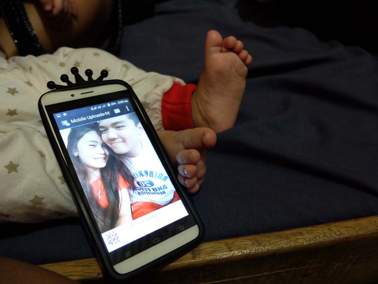 FAMILY PICTURE. Here is a photo of Hideyoshi and Michel on her phone, propped up against Hyree’s tiny feet. That’s the only family picture they will ever have. Photo by Ana Santos/Rappler 