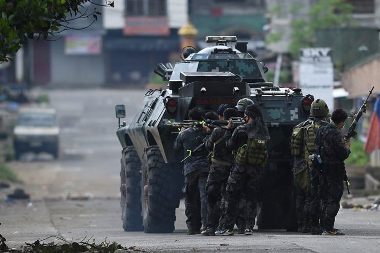 ASSAULT. Members of the police special forces maneuver as they assault Muslim militants' hide out near the city hall in Marawi City on May 28, 2017. File photo by Ted Aljibe/AFP  